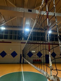 an indoor volleyball court with net and lights