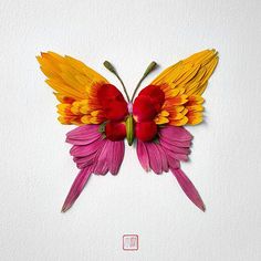 a paper sculpture of a colorful butterfly on a white background with red, yellow and pink petals