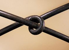 a close up view of a metal fence with a knot at the top and bottom