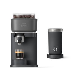 an espresso machine next to a cup with coffee beans in it on a white background