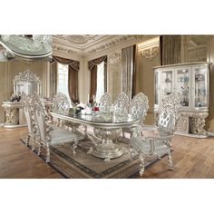 an ornate dining room set with glass table and chairs