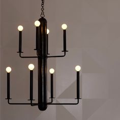 a black chandelier with five lights hanging from it's center and four arms