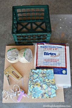 sewing supplies laid out on top of a piece of paper next to a green basket