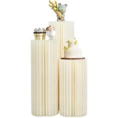 two tall white cakes sitting on top of each other in front of a white background