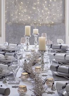 the table is set with candles and place settings for an elegant winter dinner or celebration