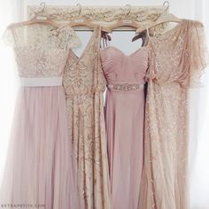 three bridesmaid dresses hanging up in front of a mirror