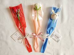 four different types of candy wrapped in cellophane and tied with ribbons on a white sheet