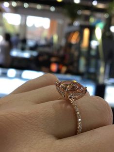 a close up of a person's hand with a diamond ring on their finger