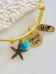 "Whimsical beach girl bangle bracelet features adjustable high quality tarnish resistant gold plated bangle with antique gold starfish and flip flop sandal charms, hand stamped \"Beach Girl\" charm and aqua blue Czech cultured sea glass accent. Charms include artisan Nunn Design antique gold plated starfish and antique gold tone flower flip flop. Both are lead and nickel free and made in USA. Hand stamped \"Beach Girl\" charm is 5/8\" 24 gauge brass disc. Adjustable gold plated bangle has 2.5\" Adjustable Gold Charm Bracelet For The Beach, Gold Charm Bracelet With Starfish For Beach, Adjustable Gold Charm Bracelet Ocean-inspired, Gold Ocean-inspired Starfish Bracelets, Gold Starfish Bracelet With Starfish Charm, Gold Beachy Bracelet For Gifts, Beachy Gold Bracelets For Vacation, Beachy Adjustable Gold Jewelry, Gold Beachy Bracelet For Gift