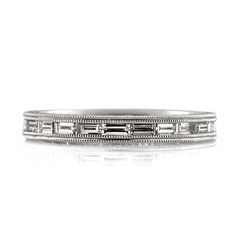 a white gold wedding band with baguetts and diamonds on the sides, set in 18k white gold