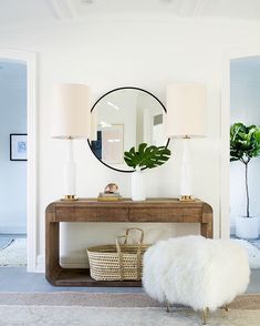 a living room with a table and mirror on the wall