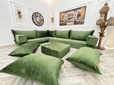 a large green couch sitting on top of a wooden floor