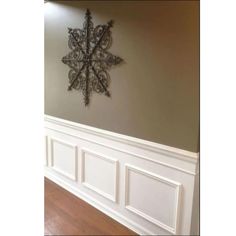 an ornate snowflake is mounted on the wall above a wood flooring area