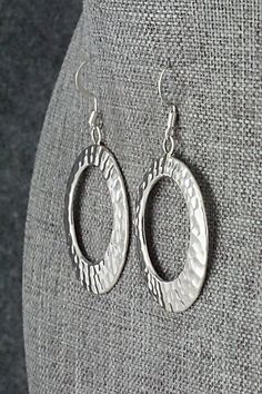 These sterling silver earrings were made by Navajo silversmith Pauline Nelson. The backs are signed N and stamped sterling.Length: 2"Width: 1 3/16"Free shipping on all orders! We ship with USPS and always include tracking. All orders ship within a day of payment.Returns are accepted up to 30 days after you receive your order. Just send us a message. Our shop offers cash back or store credit. The item must be returned in new condition. Southwestern Sterling Silver Jewelry In Silver, Hammered Sterling Silver Earrings For Anniversary, Anniversary Sterling Silver Hammered Earrings, Anniversary Hammered Sterling Silver Earrings, Artisan Nickel-free Silver Earrings, Artisan Silver Nickel-free Earrings, Hammered Sterling Silver Oval Jewelry, Oval Hammered Sterling Silver Jewelry, Artisan Silver Nickel-free Hoop Earrings