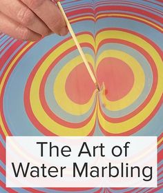 the art of water marbling with an image of a person holding a stick in front of