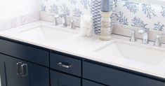 two sinks in a bathroom with blue and white wallpaper