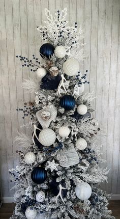 a white christmas tree with blue and silver ornaments