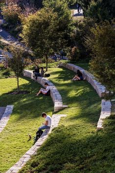 two people sitting on the grass in a park