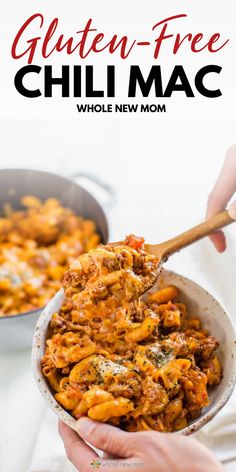 two hands holding a bowl full of gluten - free chili mac and cheese