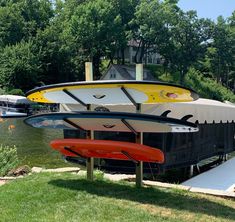 three surfboards are stacked on top of each other in front of a boat dock