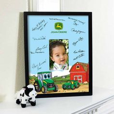 a photo frame with a farm scene and a toy cow sitting next to it on a shelf