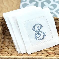 three white napkins sitting on top of a wicker basket