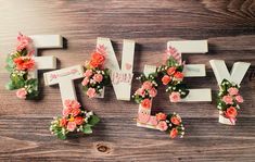 flowers are arranged in the shape of letters that spell out love on a wooden surface