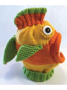 a knitted fish toy with big eyes on it's head and green legs