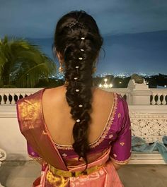 a woman with long hair wearing a pink sari