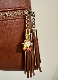 a brown purse with a cow keychain hanging from it's side