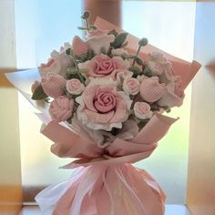 a bouquet of pink roses wrapped in ribbon