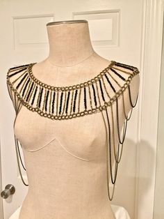 This stunning, elegant, and trendy shoulder jewelry piece was made of bronze and black color little beads on a bronze color wire and of same colors nickel-free chains. Unique, eye-catching shoulder necklace. Made by Mirela Skikic Voss - U.S.A. Indeed, unique piece of jewelry. It can be worn over the shoulders with or without shirt; with or without sleeves. It matches almost every color of your outfit. It also can be worn for any occasion - formal as well as with jeans. Bohemian Gold Metal Body Chain, Gold Bohemian Body Chain, Gold Bohemian Body Chain With Beaded Details, Bohemian Gold Beaded Body Chain, Gold Bohemian Beaded Body Chain, Bronze Jewelry For Party, Adjustable Beaded Chain Body Jewelry, Handmade Gold Body Chain For Party, Unique Gold Metal Body Jewelry