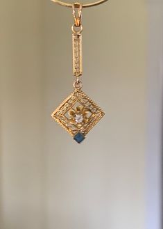 "This is a beautiful vintage Art Deco long 10k yellow gold pendant featuring a delicate filigree bar leading to a diamond shaped filigree centerpiece with an opened flower in the middle which has a small round prong set diamond in the flower's center with a diamond shaped blue sapphire at the very tip.  Measures approx. 1 1/4\" top of bail to bottom of sapphire x 1/2\" at the widest part. Weighs .3 grams. Marked 10k on the inside of the bail. This beautiful piece was my grandmother's from the 19 Flower Center, Yellow Gold Pendants, Diamond Shaped, Sapphire Gemstone, Vintage Art Deco, Diamond Shapes, Gold Pendant, Prong Setting, Blue Sapphire