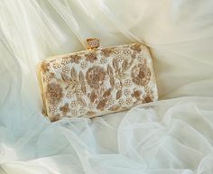 Thank you for visiting my shop! --- **Handcrafted Zardozi Embroidered  Floral Clutch - Luxurious & Elegant Design** Add a touch of timeless elegance to your wardrobe with this exquisite handmade clutch. Adorned with intricate gold floral embroidery on a soft, velvety base, this clutch is the epitome of sophisticated luxury. The delicate metallic flower motifs and stunning craftsmanship make it the perfect statement accessory for weddings, parties, or special occasions. **Features  **Color Champagne with gold floral embroidery - **Material High-quality velvet with gold-tone metal accents - **Luxurious Embroidery Hand-stitched golden floral patterns for a classic, ornate look - **High-Quality Craftsmanship Expertly crafted to ensure durability and a premium finish - **Chic Rose Clasp Topped Luxury Zari Work Clutch For Wedding, Gold Evening Bag With Pearl Embroidery For Reception, Festive Gold Evening Bag With Pearl Embroidery, Gold Hand-embellished Evening Bag For Wedding, Gold Evening Bag With Handwork For Reception, Gold Handwork Evening Bag For Reception, Gold Embroidered Clutch For Wedding, Traditional Gold Clutch With Pearl Embroidery, Bollywood Style Handwork Clutch For Receptions