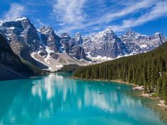 the mountains are covered in snow and blue water