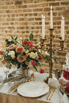 the table is set with flowers and candles