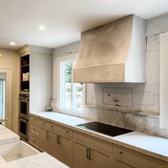 a kitchen with an oven, sink and counter tops in the middle of the room