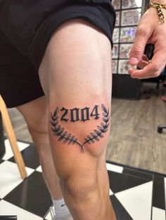 a man with a tattoo on his leg that reads, 2013 and has an laurel around it