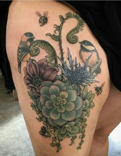 a woman's thigh with flowers and birds on it