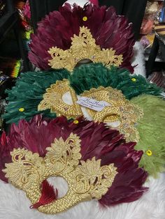 three masquerades are sitting on top of a pile of fur and feathers