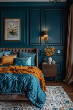 a bedroom with teal walls, blue bedding and orange pillows on the bed