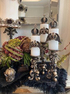 a table topped with candles and flowers next to a mirror