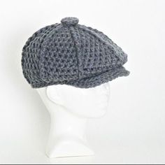 a white mannequin head wearing a gray knitted hat