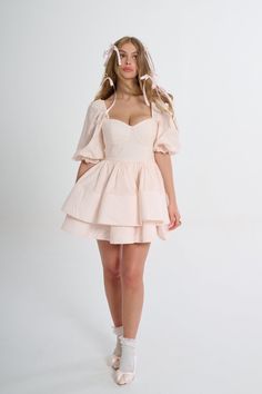 Glide through the day with elegant ease in the Lickety Split Vacation Dress. You’ll fall in love with its romantic sweetheart neckline, billowy puff sleeves, and structured tiered skirt. The color is the palest pink of satin pointe shoes and the flouncy double tiers that evoke flower petals. Pack this for a romantic weekend getaway: twirl through flower conservatory, toast at a wine tasting, and then share fresh pastas at a tiny Italian restaurant. Underwire cups Puff sleeves Two layers of offse Feminine Puff Sleeve Dress With Sweetheart Neckline And Ruffles, Feminine Puff Sleeve Dress With Ruffles And Sweetheart Neckline, Feminine Fitted Tiered Puff Sleeve Dress, Pink Puff Sleeve Dress With Sweetheart Neckline And Ruffles, Feminine Puff Sleeve Dress With Sweetheart Neckline, Feminine Fitted Puff Sleeve Dress With Tiered Skirt, Feminine Voluminous Pink Dress, Feminine Puff Sleeve Dress With Ruffles For Wedding, Feminine Tiered Puff Sleeve Dress For Garden Party