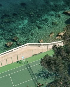 an aerial view of a tennis court near the ocean