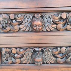 an ornate carved wood panel with flowers and leaves on the top, in front of a wooden door