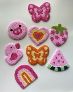 several felt appliques are arranged on a white surface