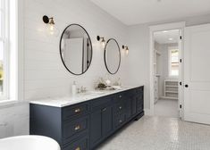 a bathroom with two sinks and mirrors on the wall