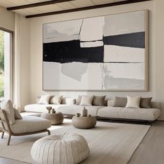 a living room filled with furniture and a large painting hanging on the wall above it