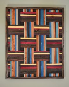 a wooden wall hanging with multicolored strips on it